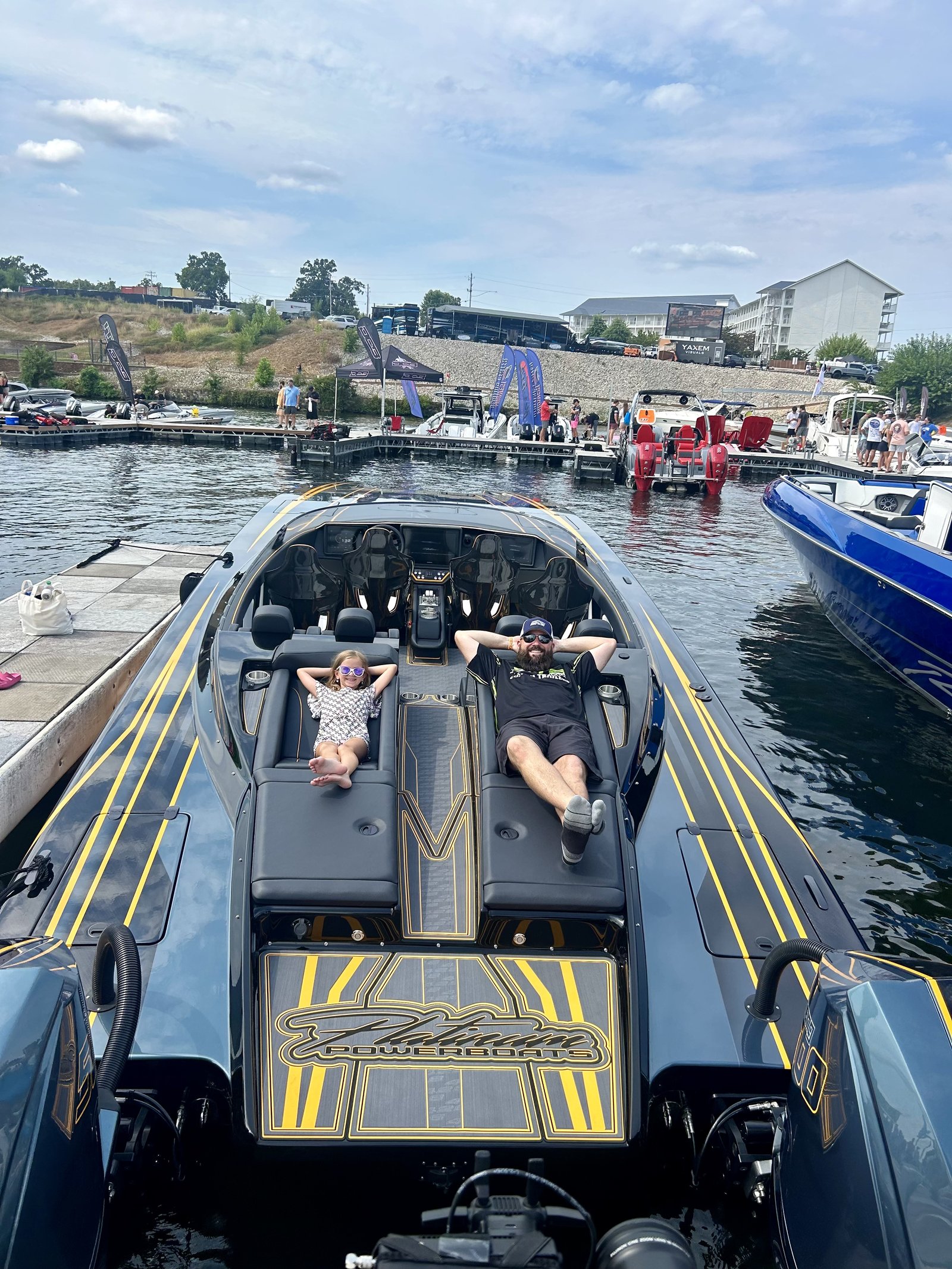 Guests reclining on the Platinum 428's rear-facing power sun-lounges at the dock